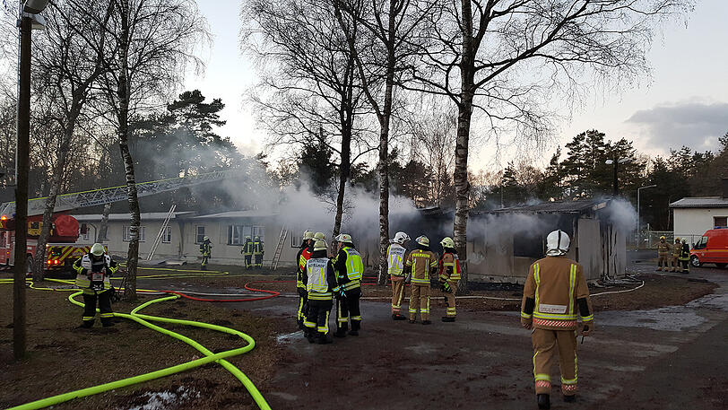 Feuerwehrkräfte löschen den Brand in einer Flüchtlingsunterkunft in Hövelhof bei Paderborn.