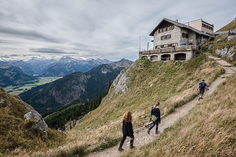 Wanderer gehen zur Bad Kissinger Hütte des Deutschen Alpenvereins.