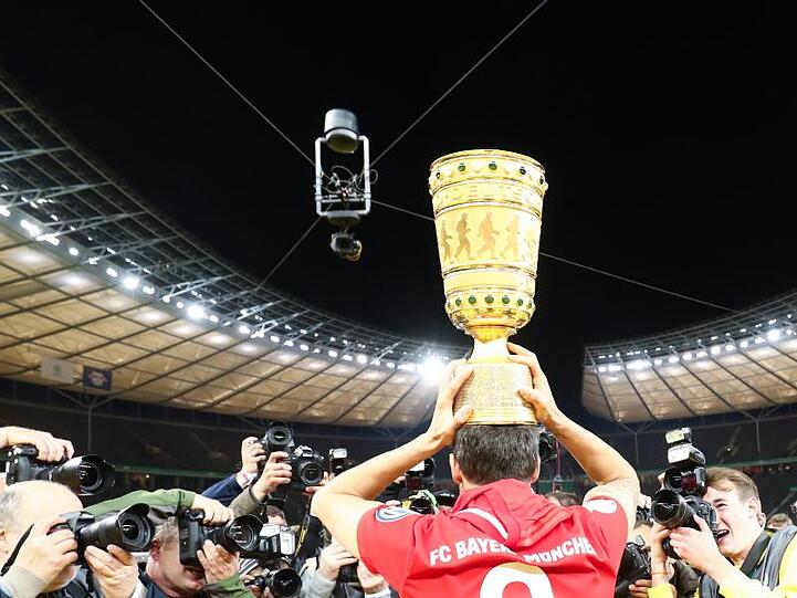 Bayerns Javi Martínez trägt den Pokal auf dem Kopf.