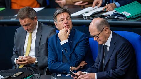 Finanzminister Christian Lindner neben Wirtschaftsminister Robert Habeck und Bundeskanzler Olaf Scholz (v.l.n.r.) während einer Bundestagssitzung.