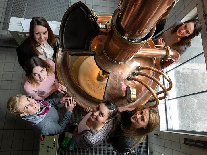 Die Finalistinnen bei der Wahl der bayerischen Bierkönigin stehen in der "Gläsernen Brauerei" an einem Kessel. Foto: Daniel Karmann/Archiv