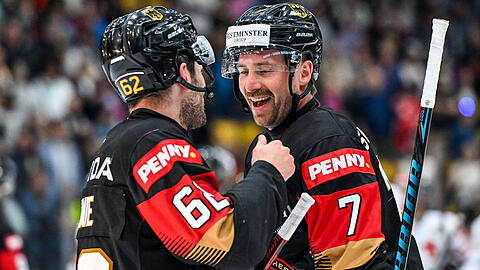 Da hat er gut lachen: EHC-Star Maximilian Kastner (r., mit Parker Tuomie) im Trikot der deutschen Eishockey-Nationalmannschaft beim L&auml;nderspiel gegen &ouml;sterreich in seiner Heimat Garmisch-Partenkirchen