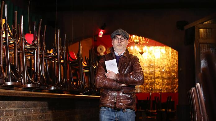 Die Hocker auf dem Tresen und das Buch umklammert: Thomas Vogler in seiner Jazzbar.