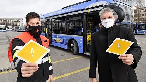 Michael Gaertner, Ausbildungsleiter "Technische Unfallrettung" an der Feuerwehr- und Rettungsdienstschule der Feuerwehr München (l.) und MVG-Buschef Veit Bodenschatz präsentieren die Kennzeichnungen für E-Busse.