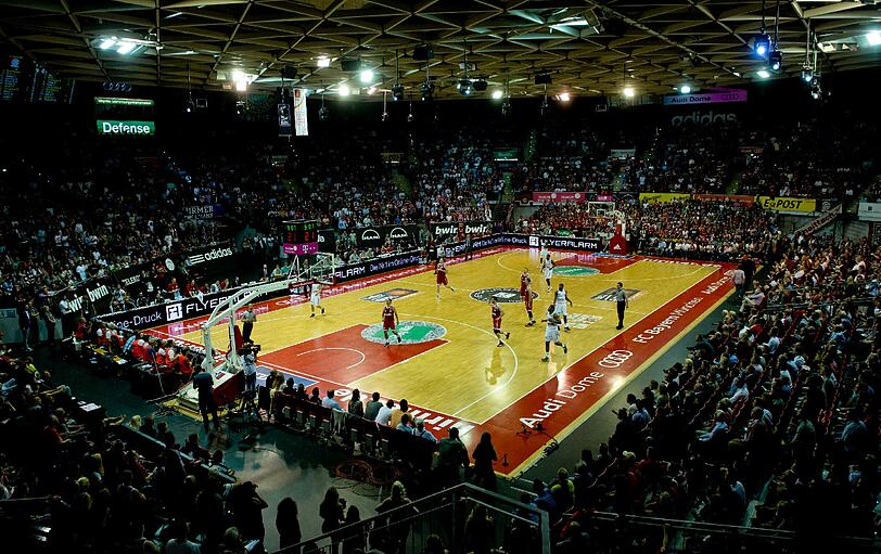 Die Spieler von München und Bamberg kämpfen auf dem Spielfeld um den Ball.