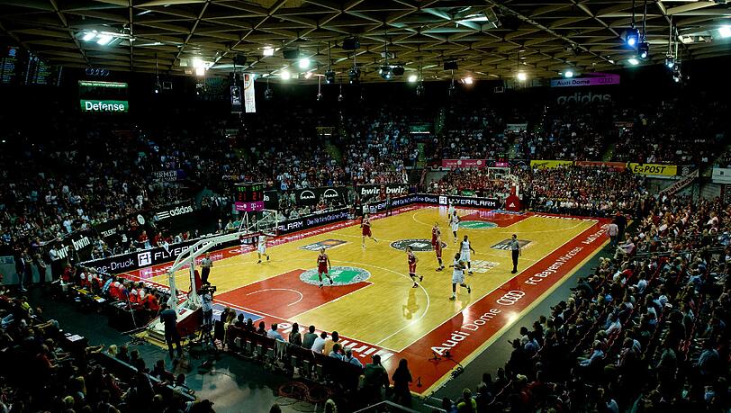 Die Spieler von München und Bamberg kämpfen auf dem Spielfeld um den Ball. Die Spieler von München und Bamberg kämpfen auf dem Spielfeld um den Ball.