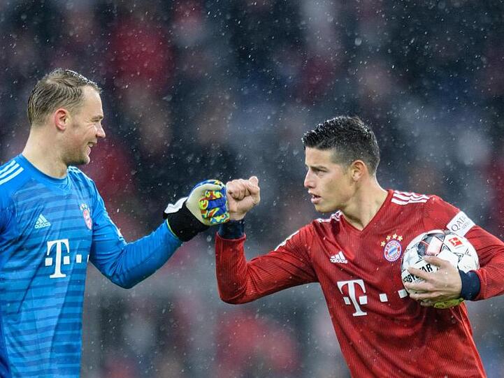 Dreifachtorschütze James Rodríguez (r) feiert mit Torwart Manuel Neuer den Sieg des FC Bayern München.