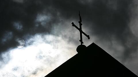 Vor wolkenverhangenem Himmel ist die Kirchturmspitze eines Doms zu sehen. Foto: Friso Gentsch/dpa/Archivbild