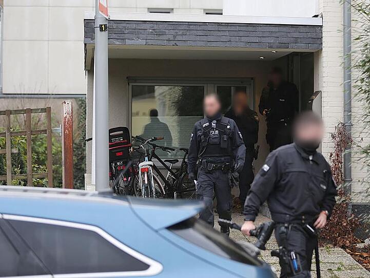 Polizisten verlassen das Wohnhaus eines Italieners in Pulheim: Bei den großangelegten Razzien waren 440 Beamte beteiligt.