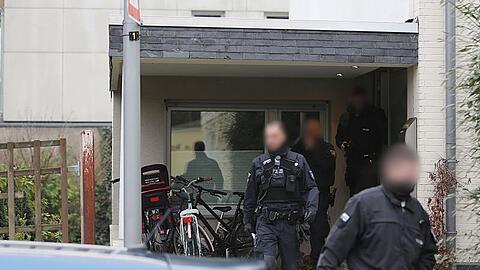 Polizisten verlassen das Wohnhaus eines Italieners in Pulheim: Bei den großangelegten Razzien waren 440 Beamte beteiligt.