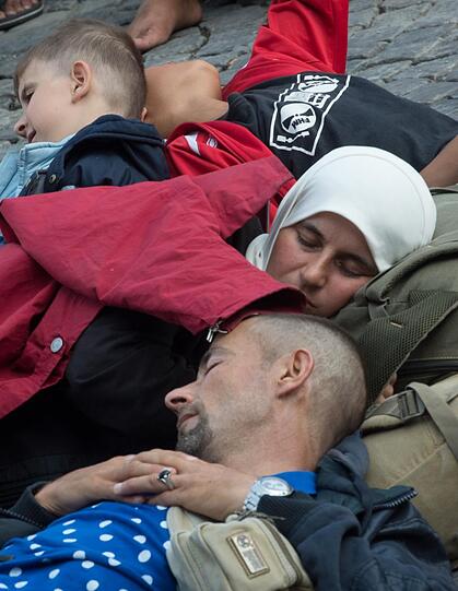 Geschafft: Erschöpft schlafen diese Flüchtlinge auf dem Gehsteig