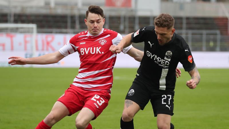Der Würzburger Florian Flecker (l) kämpft mit Robin Scheu von Sandhausen um den Ball.