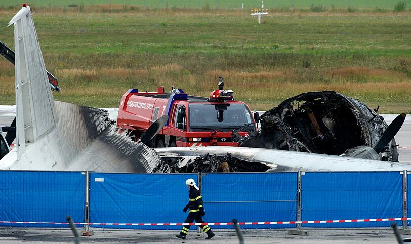 Einsatzkräfte der Feuerwehr und des Flughafens Leipzig/Halle sichern am 09.08.2013 im Frachtbereich des Flughafens in Schkeuditz (Sachsen) eine ausgebrannte Frachtmaschine.