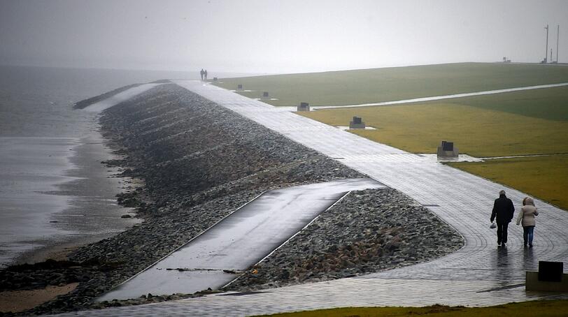 Spaziergänger gingen am Donnerstag in Büsum (Schleswig-Holstein) am Nordseedeich entlang. In den kommenden Tagen werden an der Küste Stürme mit Orkanböen erwartet.