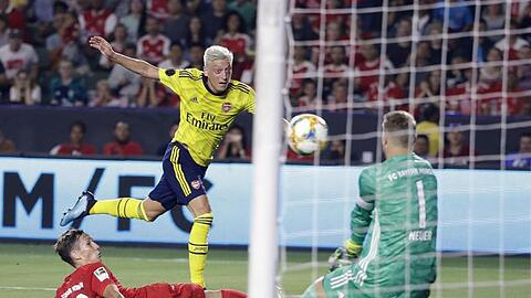 Münchens Jonas Kehl (l) und Torhüter Manuel Neuer (r) gegen Arsenals Mesut Özil. Foto: Marcio Jose Sanchez