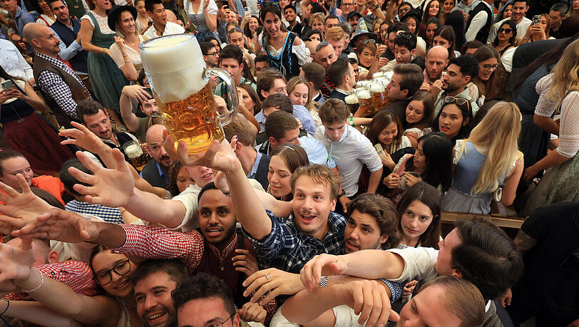 Oktoberfestbesucher versuchen nach dem Anzapfen im Paulaner-Festzelt ein Freibier zu ergattern.