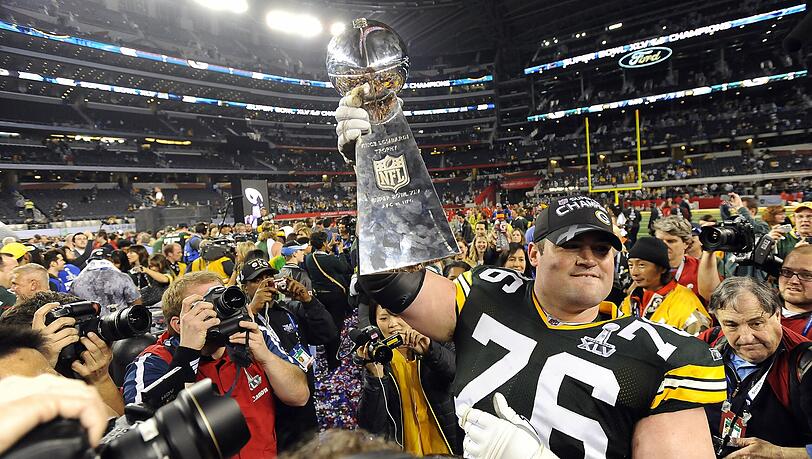 Green Bay Packers-Spieler Scott Wells hält die Vince Lombardi Trophäe in den Nachthimmel von Texas. Green Bay Packers-Spieler Scott Wells hält die Vince Lombardi Trophäe in den Nachthimmel von Texas.