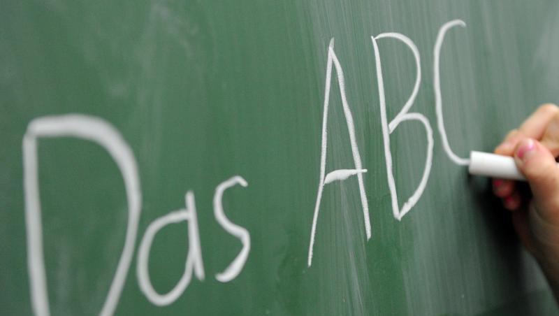 Eine Grundschülerin schreibt das ABC an die Tafel. Eine Grundschülerin schreibt das ABC an die Tafel.