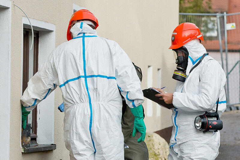 Mitarbeiter der Spurensicherung stehen am 12.12.2014 in Vorra (Bayern) an einem durch einen Brand beschädigtem Gebäude. In der Nacht hatten im Ortskern des Dorfes im Kreis Nürnberger Land ein ehemaliger Gasthof, ein nahe gelegenes Wohnhaus sowie eine Scheune gebrannt. In die Gebäude sollten in der kommenden Woche Asylbewerber einziehen.