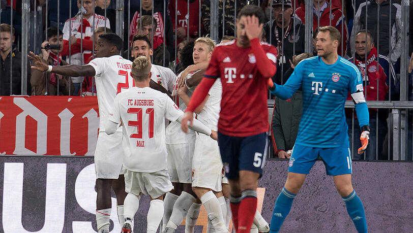 Und da ist es passiert: Die Augsburger jubeln mit Torschütze Felix Götze, Manuel Neuer realisiert, dass der Treffer auf seine Kappe geht. Und da ist es passiert: Die Augsburger jubeln mit Torschütze Felix Götze, Manuel Neuer realisiert, dass der Treffer auf seine Kappe geht.