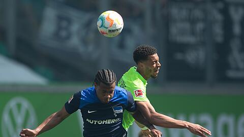 Herthas Jessic Ngankam (l) im Kopfballduell mit dem Wolfsburger Felix Nmecha.