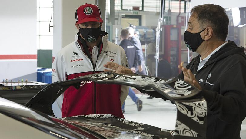 Kimi Räikkönen diskutiert mit einem Aerodynamik-Experten von Alfa Romeo über den neuen Heckspoiler. Kimi Räikkönen diskutiert mit einem Aerodynamik-Experten von Alfa Romeo über den neuen Heckspoiler.