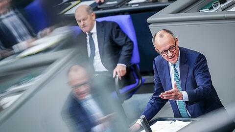 Friedrich Merz (r), Unions-Kanzlerkandidat und CDU-Bundesvorsitzender, spricht im Bundestag in der Generaldebatte "zur Situation in Deutschland" neben Bundeskanzler Olaf Scholz (SPD).