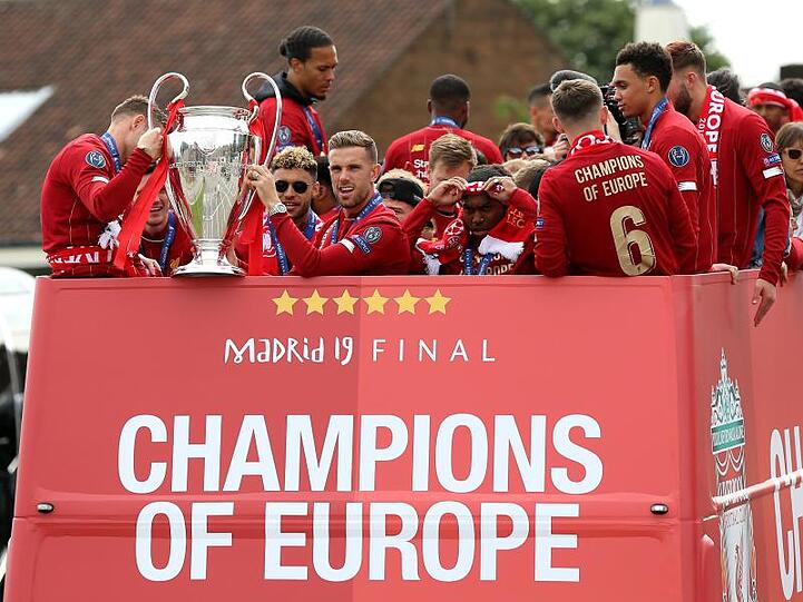 Liverpools Spieler fahren in einem offenen Bus durch die Stadt und lassen sich feiern.