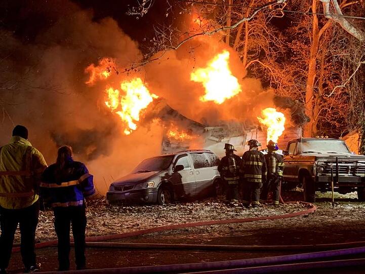 Feuerwehrleute stehen vor dem brennenden Haus am Stadtrand von Logansport.