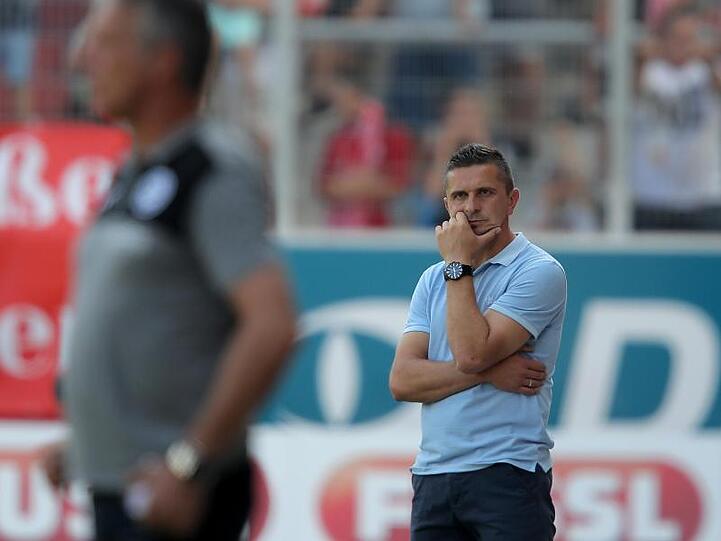 Der Regensburger Trainer Mersad Selimbegovic (r) verfolgt den Spielverlauf. Foto: Daniel Karmann