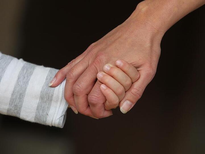 Eine Frau hält die Hand eines Kindes. Foto: Karl-Josef Hildenbrand/dpa/Archiv