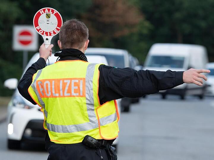 Ein Polizist steht im Rahmen eines Kontrolleinsatzes auf einem Autobahn-Parkplatz.