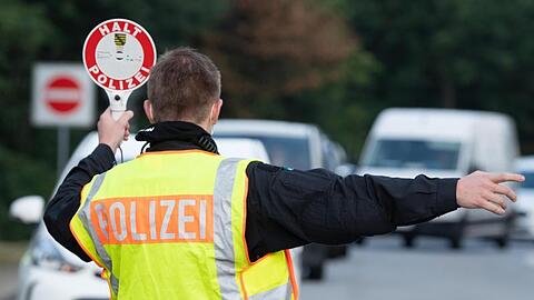 Ein Polizist steht im Rahmen eines Kontrolleinsatzes auf einem Autobahn-Parkplatz.