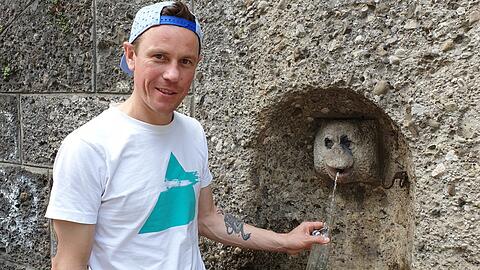 Florian Falterer zapft Wasser an "seinem" Trinkwasserbrunnen.
