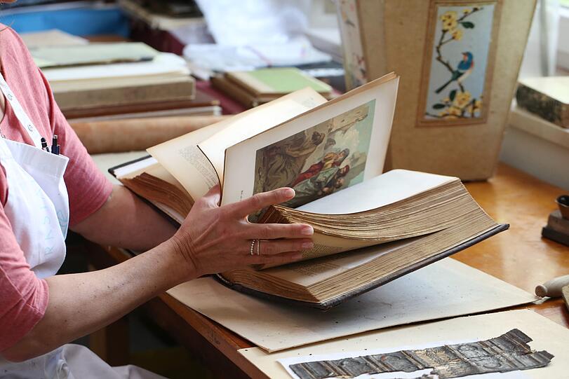 Andrea Fellinger mit einer alten, unrestaurierten Bibel.