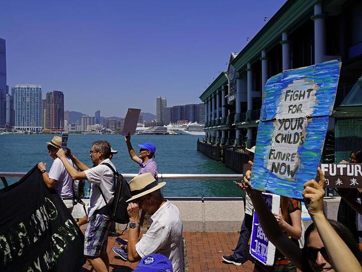Teilnehmer einer Demonstration in Hongkong halten Plakate.