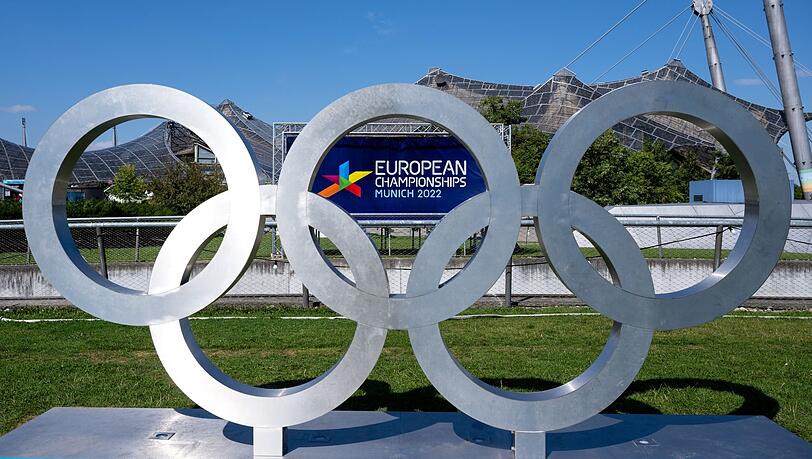 Die Olympischen Ringe und ein Plakat mit dem Logo der „European Championships 2022“. Die Olympischen Ringe und ein Plakat mit dem Logo der „European Championships 2022“.