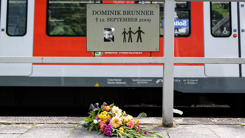 Frische Blumen mit einer Trauerschleife liegen am zehnten Jahrestag des Verbrechens unter der Gedenktafel in Solln.