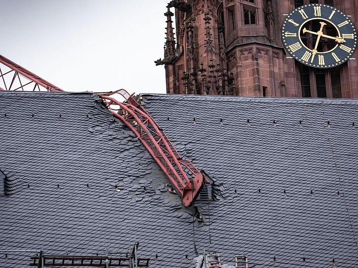 Auf den Frankfurter Dom gekracht: Der beschädigte Baukran wird vorerst gesichert und kann voraussichtlich erst Mitte der Woche entfernt werden.