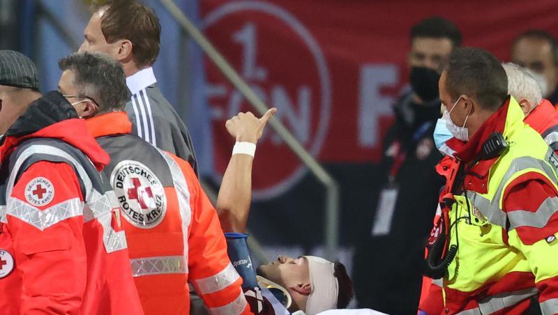 Der Nürnberger Tom Krauß (M) wird verletzt aus dem Stadion getragen, zeigt aber mit dem Daumen nach oben.