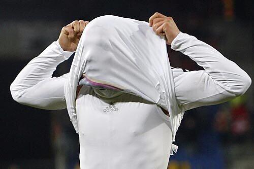 Unter dem Trikot steckt ein glücklicher und erfolgreicher DFB-Stürmer: Bayern-Star Lukas Podolski nach seinem Treffer gegen die Schweiz.
