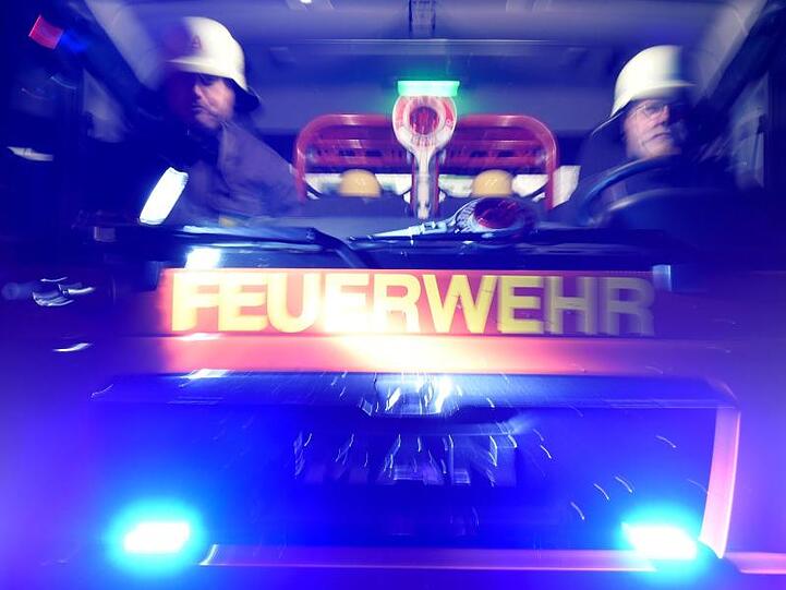Feuerwehrmänner in einem Löschfahrzeug. Foto: Carsten Rehder/Archivbild