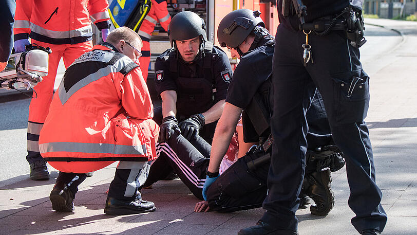 Sanitäter und Polizisten kümmern sich in Hamburg um die angeschossene Frau.