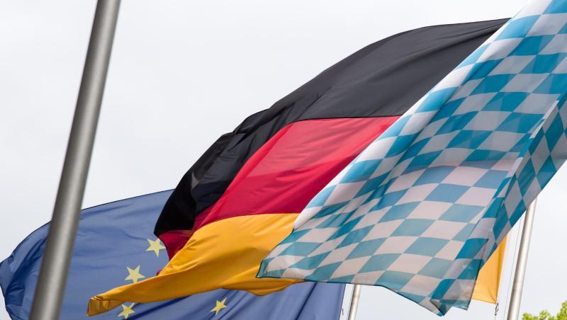 Die Europa-, Deutschland- und Bayernfahne wehen nebeneinander im Wind. Foto: Peter Kneffel/Archivbild