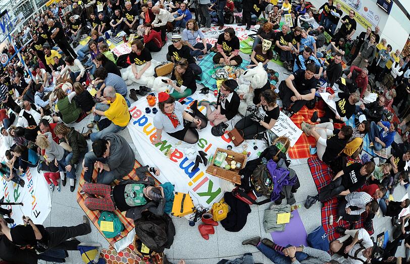 Gegen Fluglärm demonstrierende Demonstranten picknicken am Samstag (24.03.12) am Flughafen Franz-Josef-Strauss in einem Teil der Abflughalle des Terminal 2.