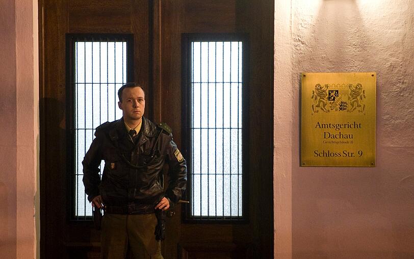 Ein Polizeibeamter steht vor dem Amtsgericht in Dachau (Oberbayern). Ein Mann hat am Mittwoch während eines Prozesses am Dachauer Amtsgericht einen Staatsanwalt erschossen.