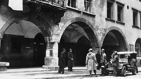 Mai 1945: Vor dem stark beschädigten Hofbräuhaus stehen US-amerikanishce Soldaten. Vom Balkon weht eine weiße Fahne.