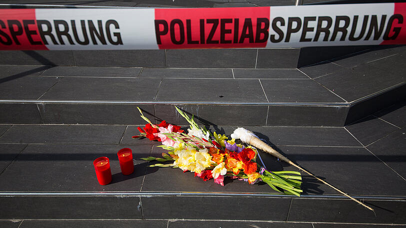 Polizeiabsperrband ist vor dem Eingang des Clubs "Grey" in Konstanz angebracht, während auf der Treppe Blumen und Kerzen als Zeichen der Trauer liegen.