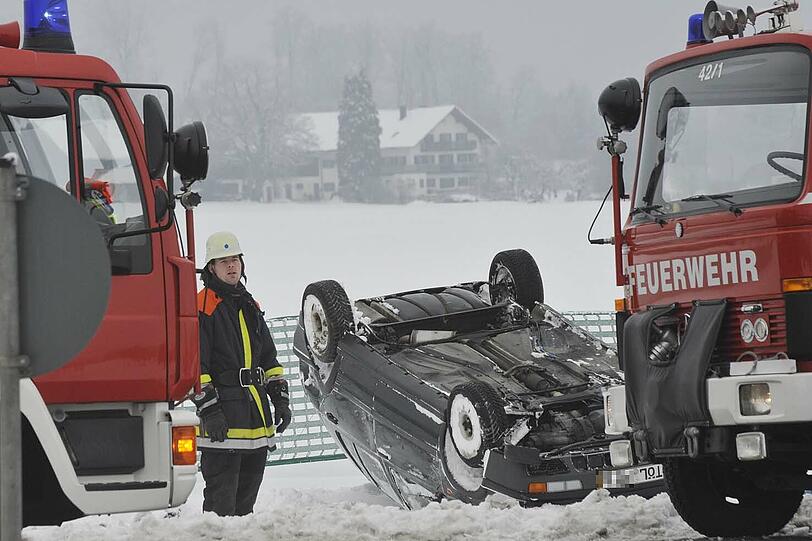 Feuerwehrmänner befreiten die verletzte Fahrerin aus dem umgestürzten Auto.