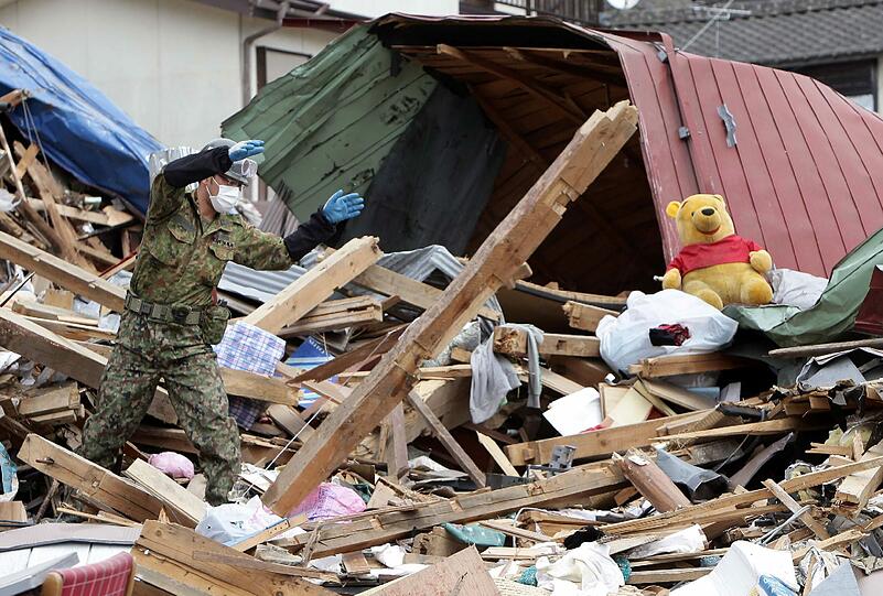 Japanische Soldaten suchen in den Trümmern in der Küstenstadt Otsuchi nach Leichen. Die genaue Zahl der Katastrophenopfer ist noch unklar.